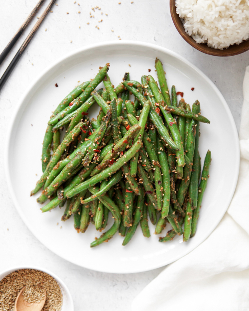 Green beans stir fried with a peanut sauce and topped with sesame seeds.
