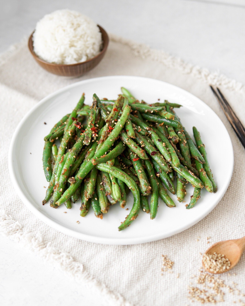 Green beans stir fried with a peanut sauce and topped with sesame seeds.