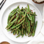 Green beans stir fried with a peanut sauce and topped with sesame seeds.