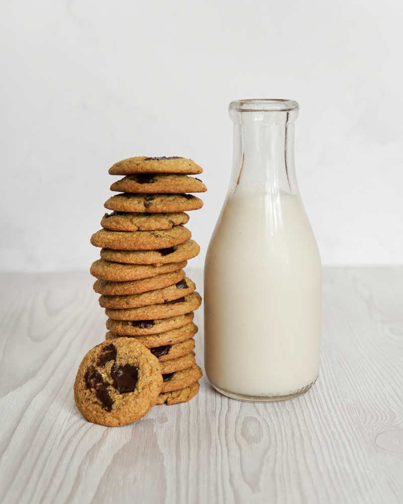 Classic chocolate chip cookies, but Low FODMAP, with a tall glass of almond milk