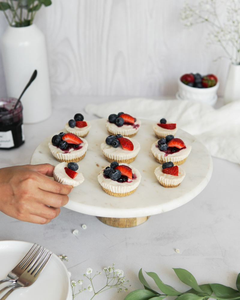 Low FODMAP, dairy free, no-bake cheesecake bites on a cake stand.