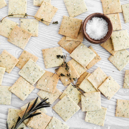 Gluten free & Low FODMAP Tuscan almond flour crackers scattered with sea salt and herbs.