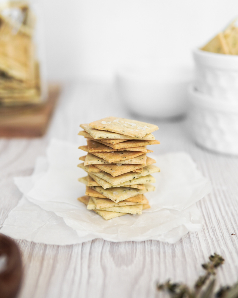 A stack of gluten free & Low FODMAP Tuscan almond flour crackers with sea salt and herbs.