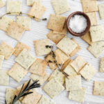 Gluten free & Low FODMAP Tuscan almond flour crackers scattered with sea salt and herbs.