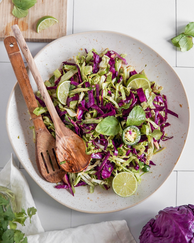 A large platter of simple, light and refreshing Asian-Style Coleslaw topped with jalapenos, mint and lime.