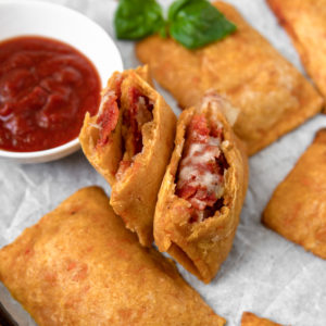 A Low FODMAP & Grain Free homemade pizza roll filled with passata, pepperoni and mozzarella, ripped open to show the hot and saucy insides.